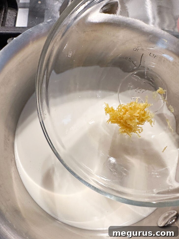 Adding lemon zest to cream in saucepan for infusion.