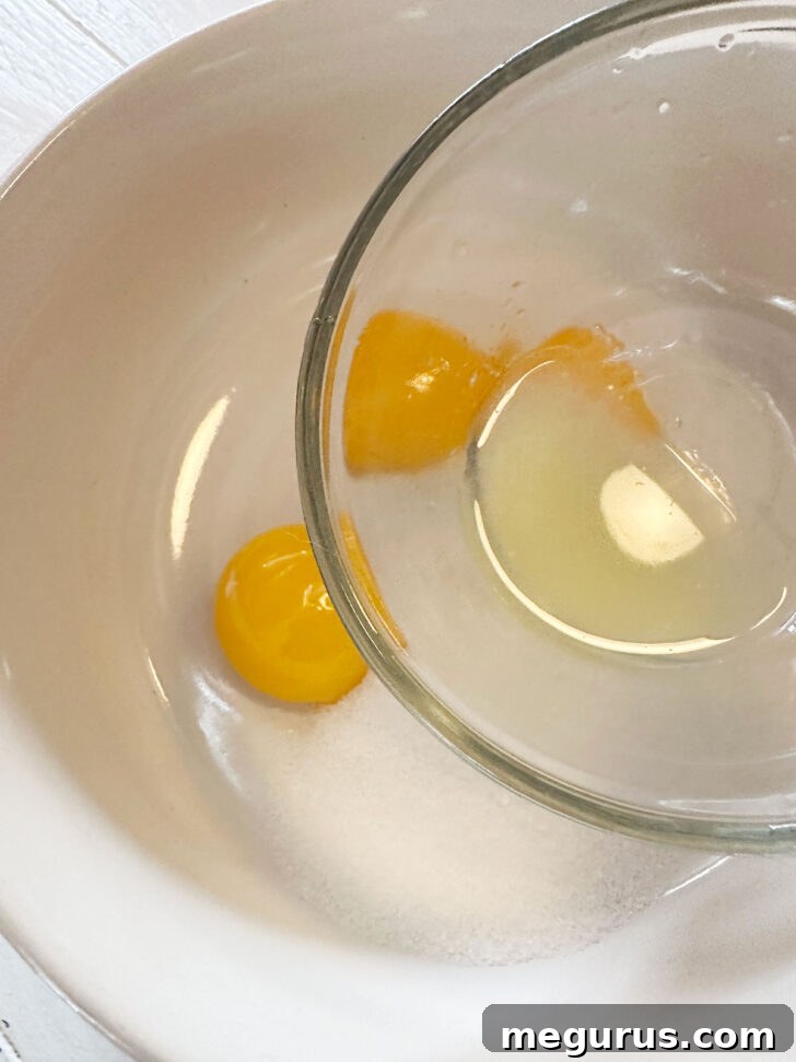 Adding lemon juice to egg yolks and sugar in a small bowl.