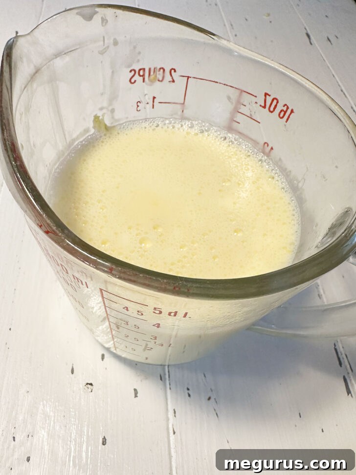 Finished custard ready to pour in ramekins from a measuring cup.