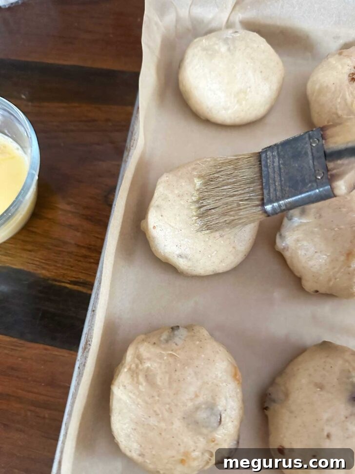 Brushing the balls with egg wash.