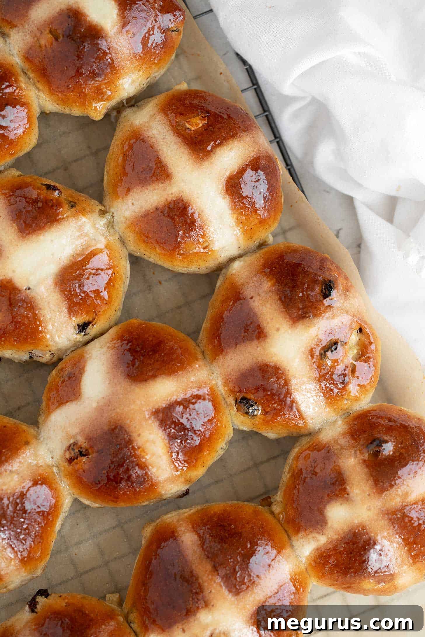 Traditional hot cross buns on cooling rack, close-up view.