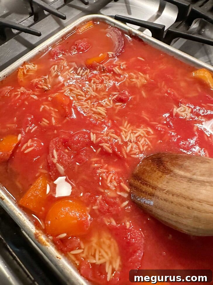 Stirring together the ingredients on the sheet pan before adding feta.