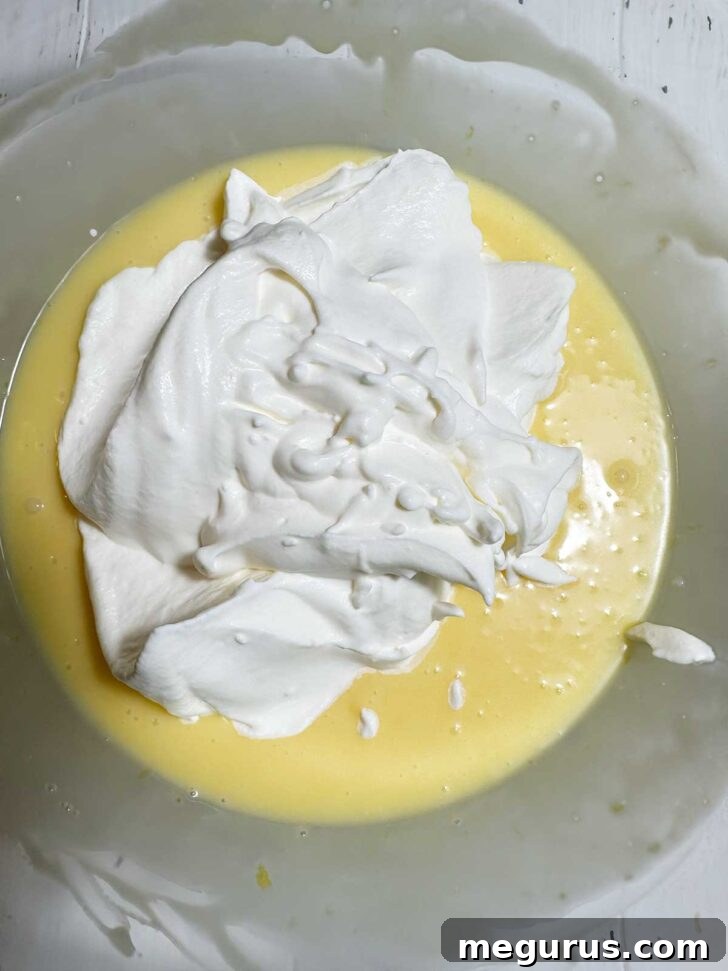 Delicate whipped cream added to the lemon curd and crème frâiche mixture, ready for gentle folding to preserve its airy texture.
