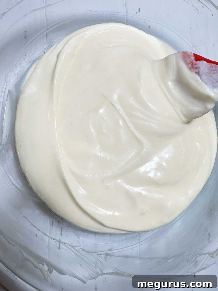The lemon curd mixture after the whipped cream has been carefully folded in, resulting in a light and homogeneous pudding texture.