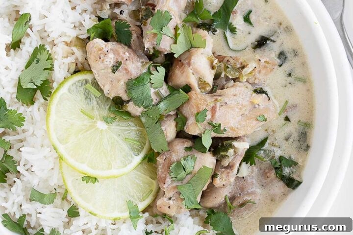 Creamy Coconut Lime Chicken in a serving bowl with rice and fresh lime slices.