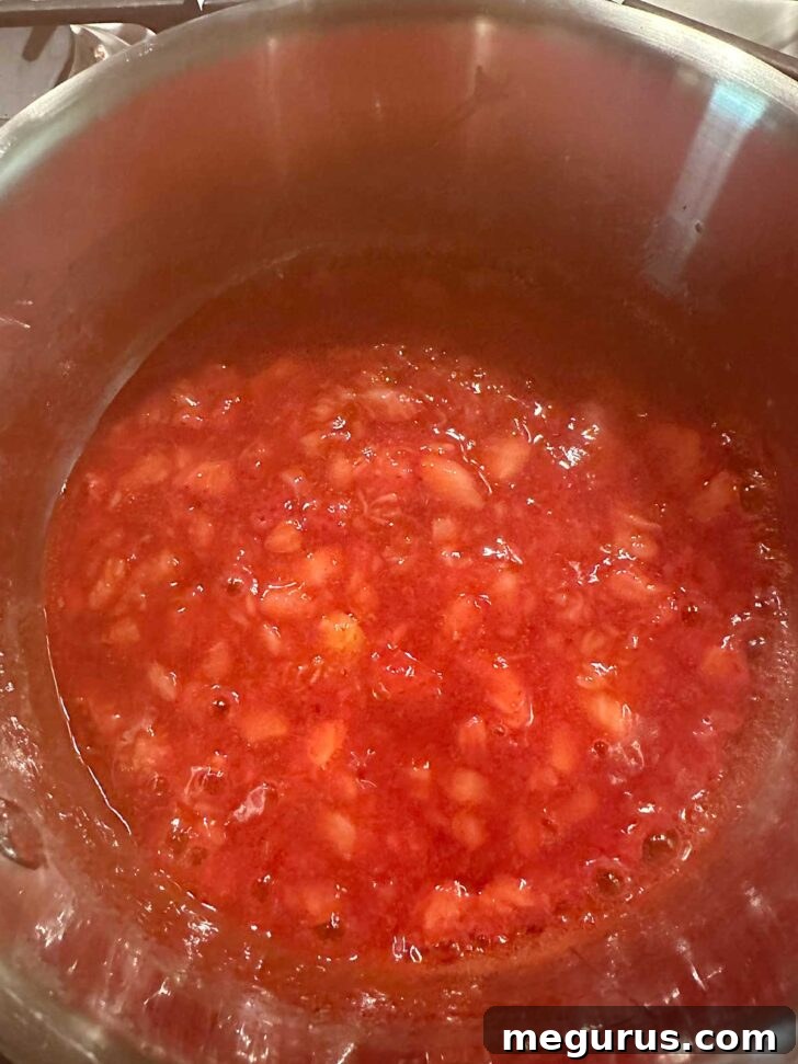Strawberries simmering in saucepan.