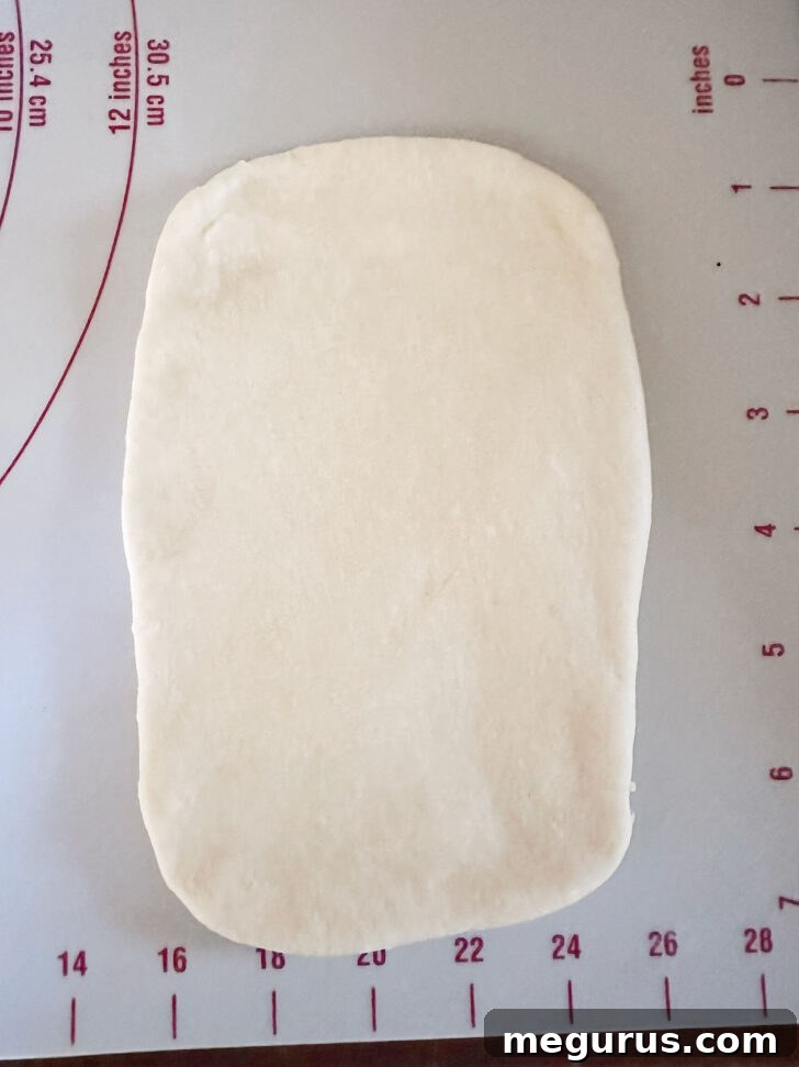 Rolling a brioche dough ball into a rectangular shape.