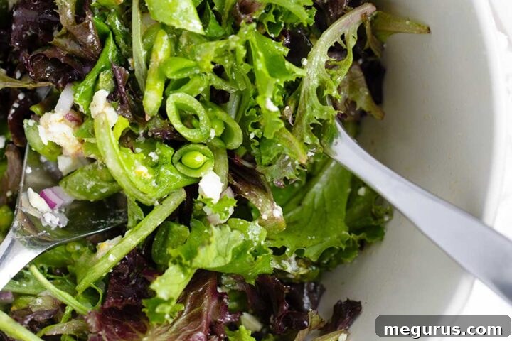 Chopped Spring salad with asparagus and snap peas in bowl.
