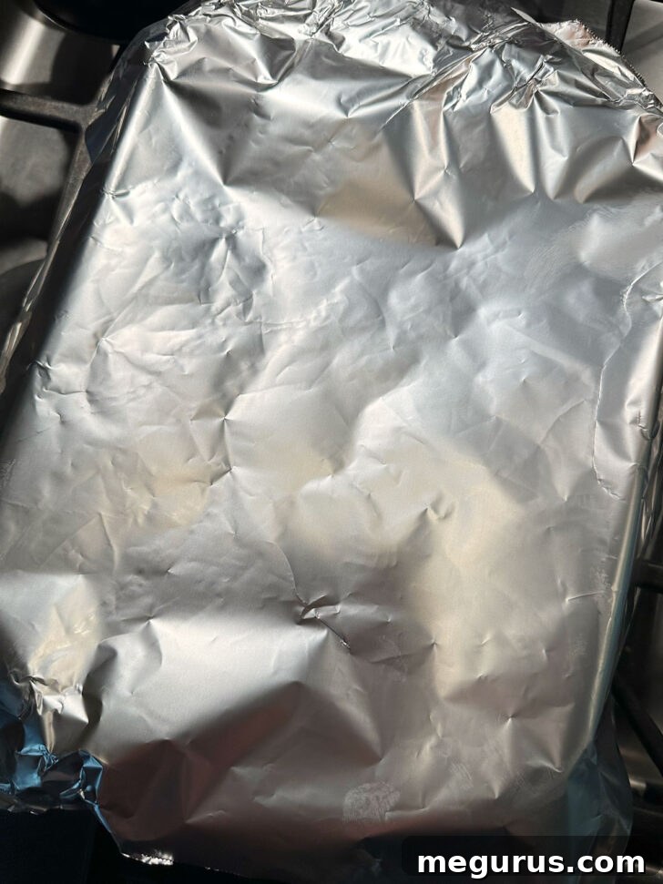 Loosely covered foil covering baking dish before baking.