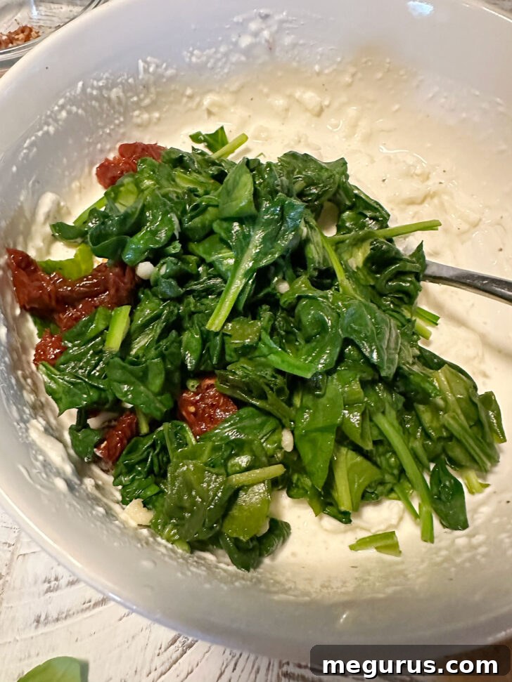 Spinach and sun-dried tomatoes added to cream cheese mixture.