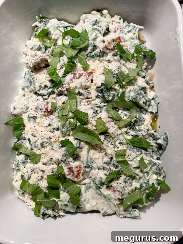 Basil added on top of cream cheese mixture in baking dish.