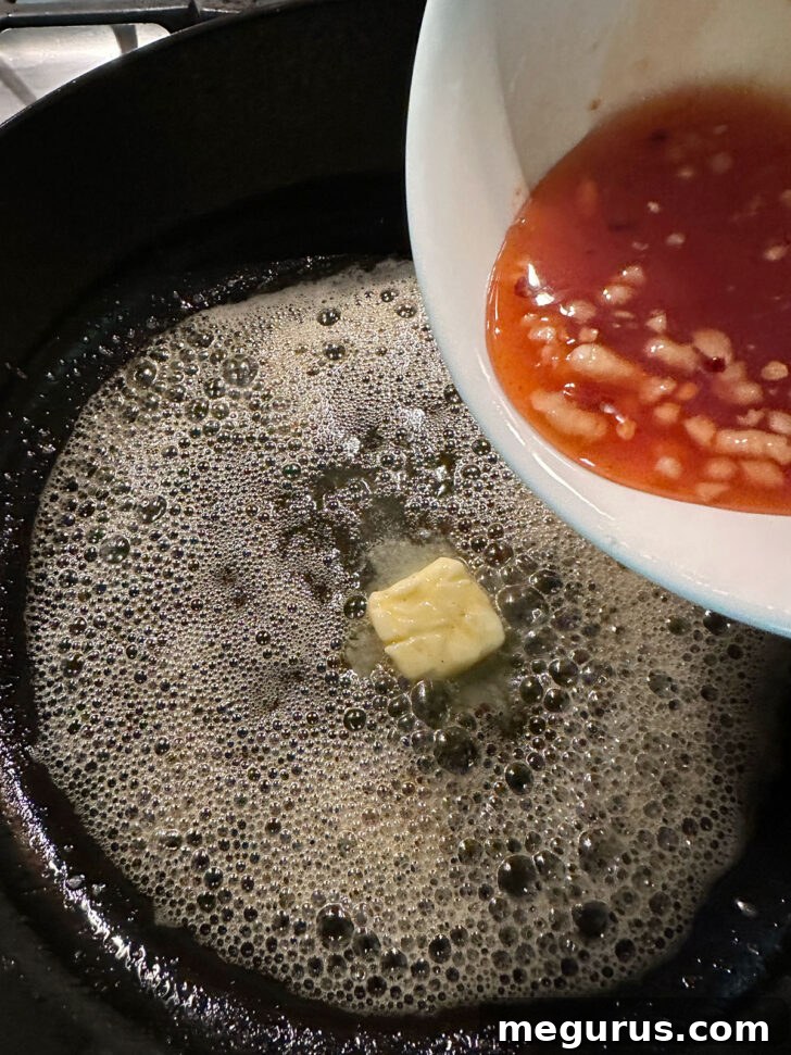 Butter melting in the skillet, followed by the addition of the hot honey sauce mixture.