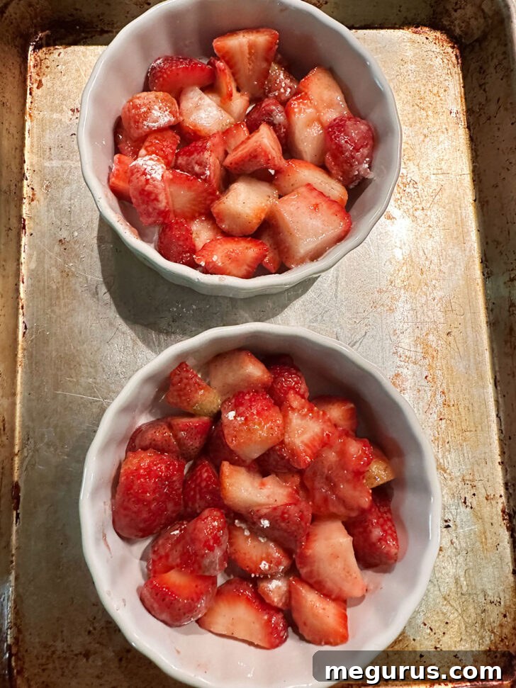 Prepared strawberries tossed with sugar and cornstarch in ramekins.