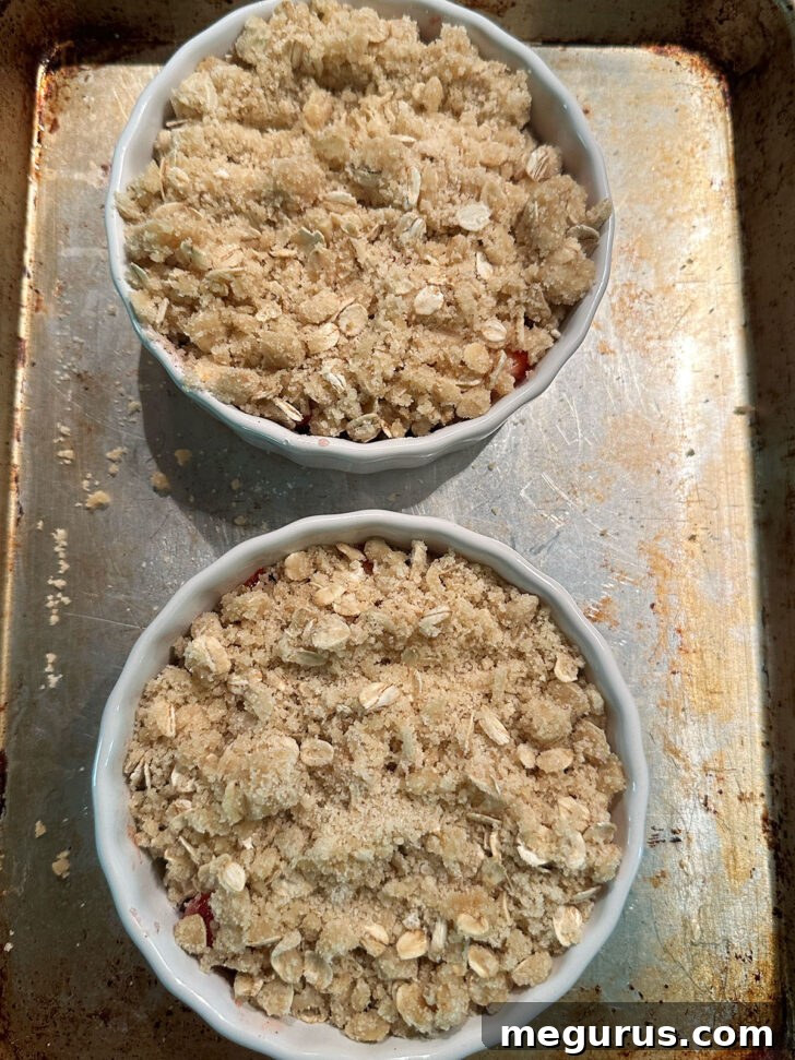 Oat topping spooned on top of the strawberries in ramekins before baking.