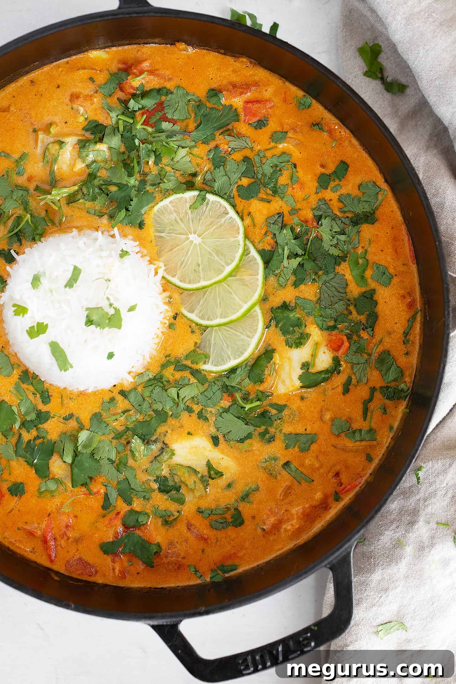 A large skillet of coconut fish curry with rice, ready to be served or stored.