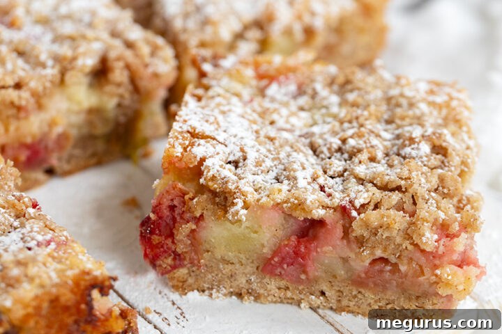 Rhubarb custard cake sliced on serving board.