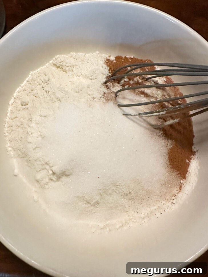 Dry ingredients for the crumb mixture, including flour, sugar, baking powder, salt, and cinnamon, are combined in a mixing bowl.