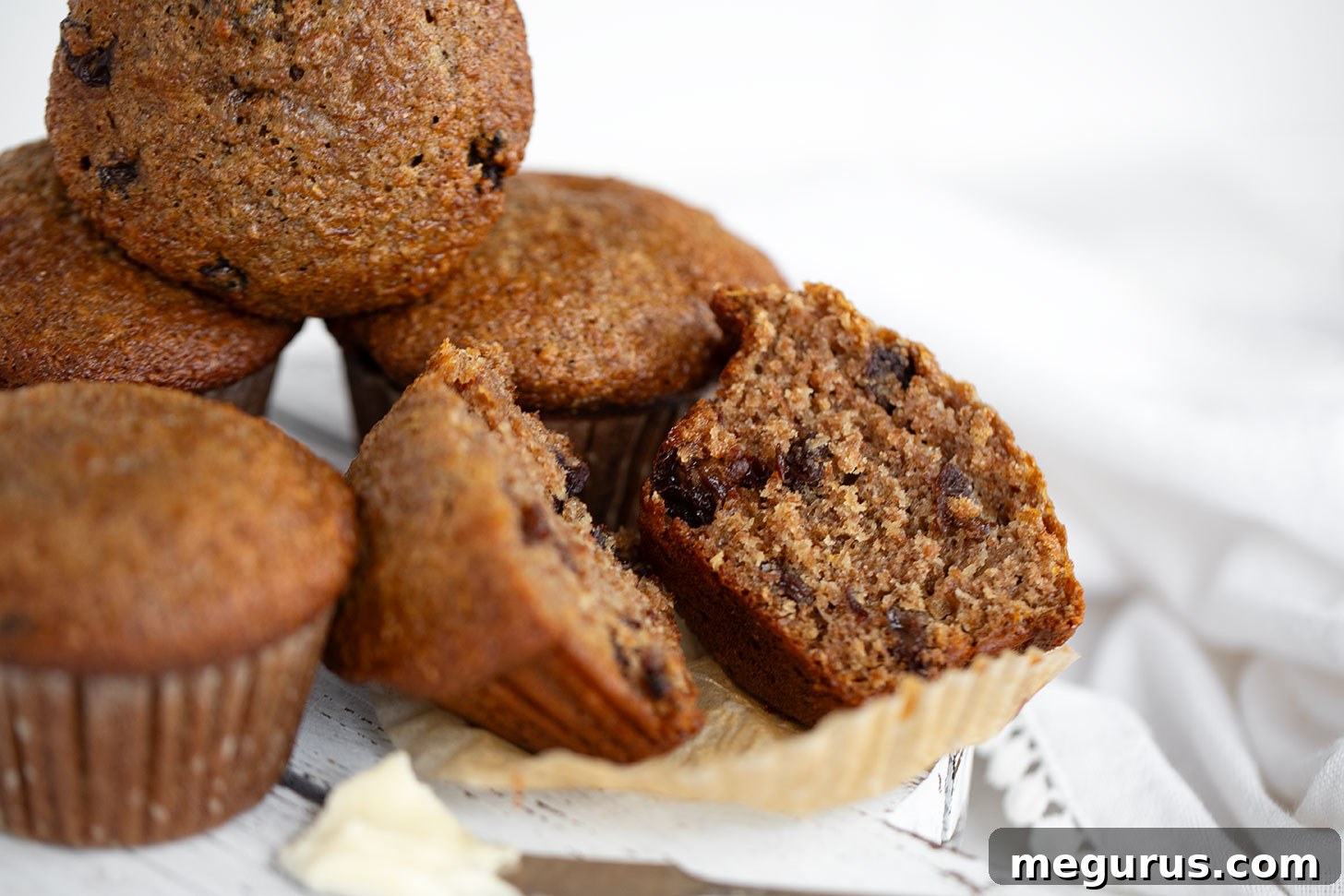 Buttermilk bran muffins sliced on board, showcasing their moist texture and golden-brown tops.