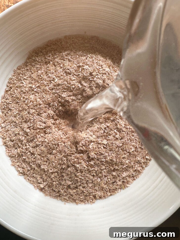 Adding boiling water to some of the wheat bran in a bowl.