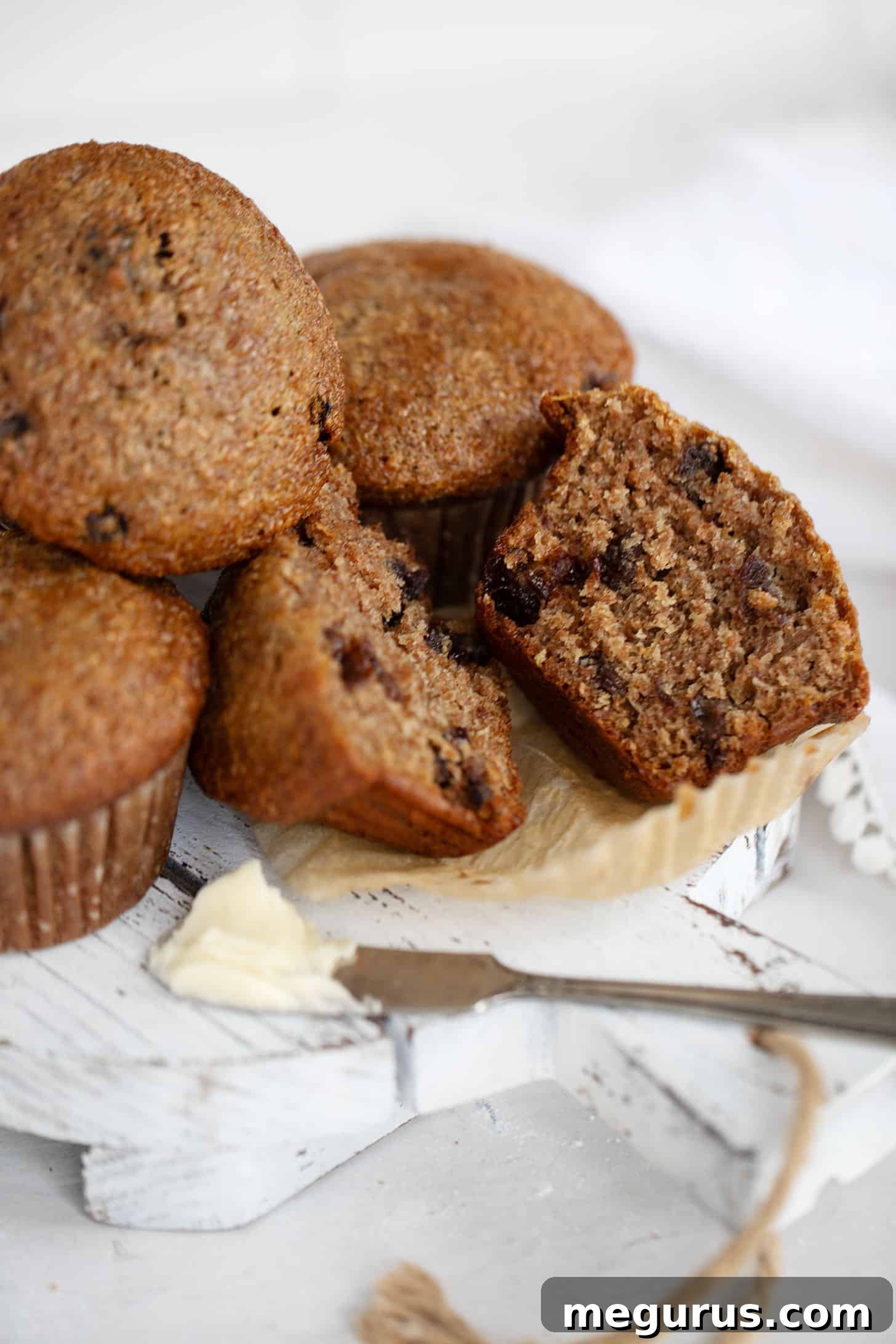Buttermilk bran muffins sliced on a cutting board, showing their fluffy, moist interior.