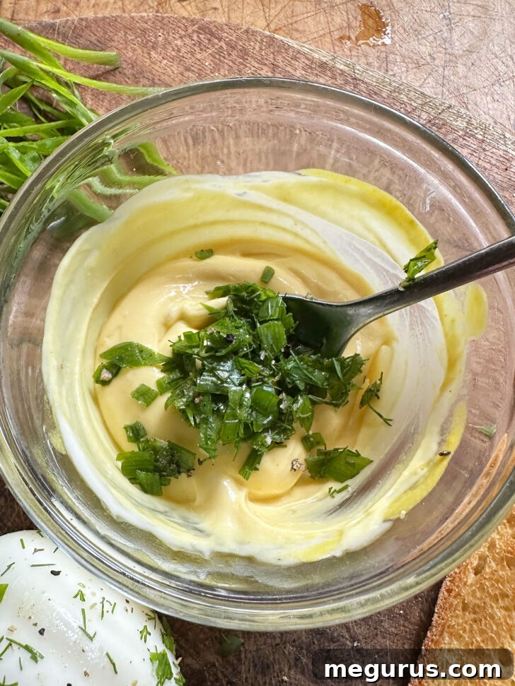Adding fresh herbs to mustard sauce.