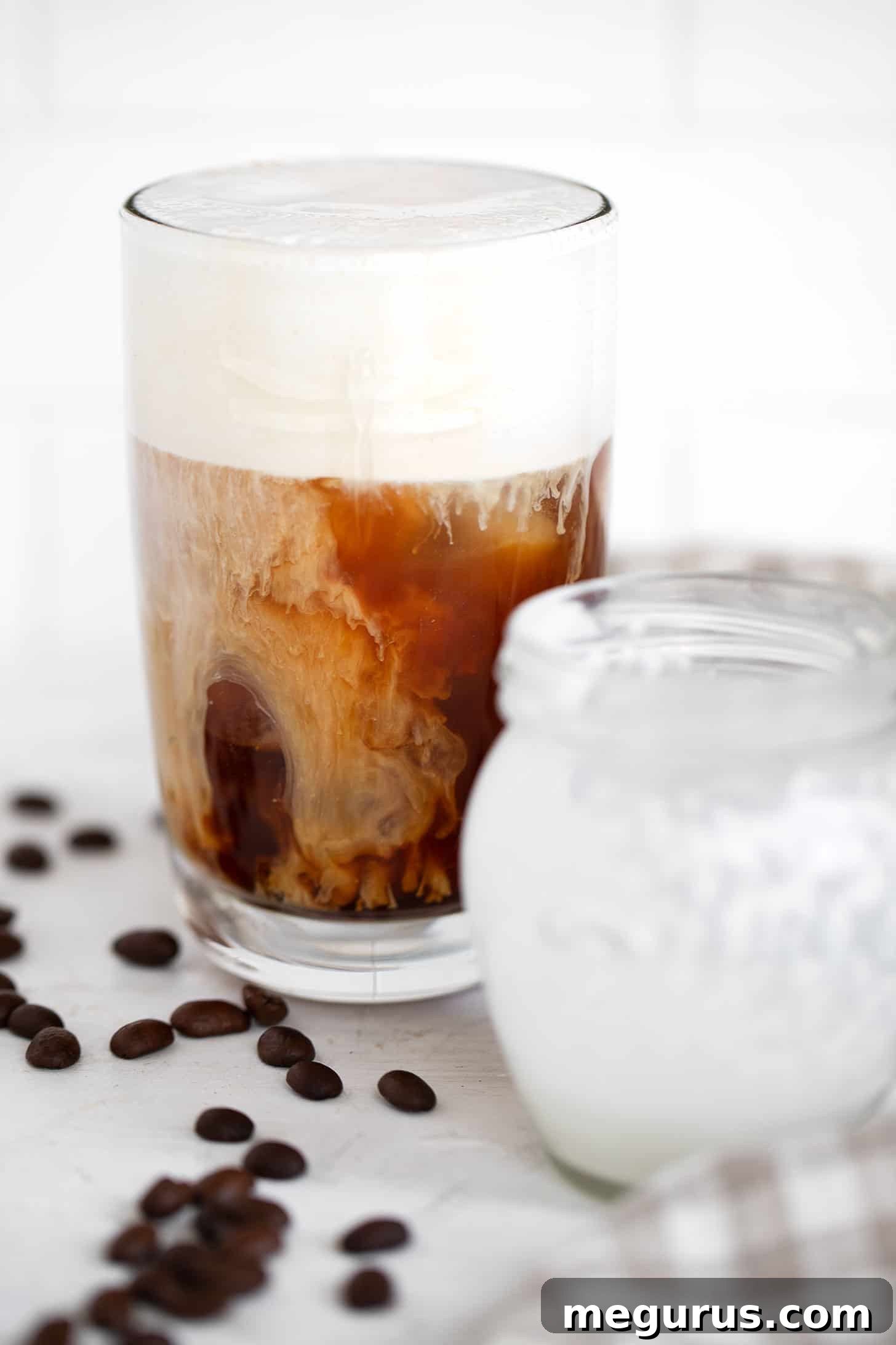 A stunning close-up of a homemade Vanilla Sweet Cream Cold Brew with a thick, perfectly frothed vanilla sweet cream layer.