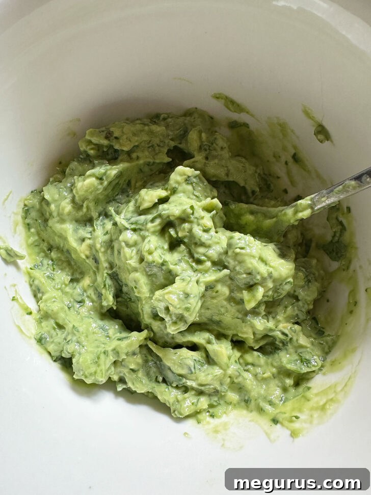 Creamy avocado cilantro lime sauce in a bowl, blended to perfection.