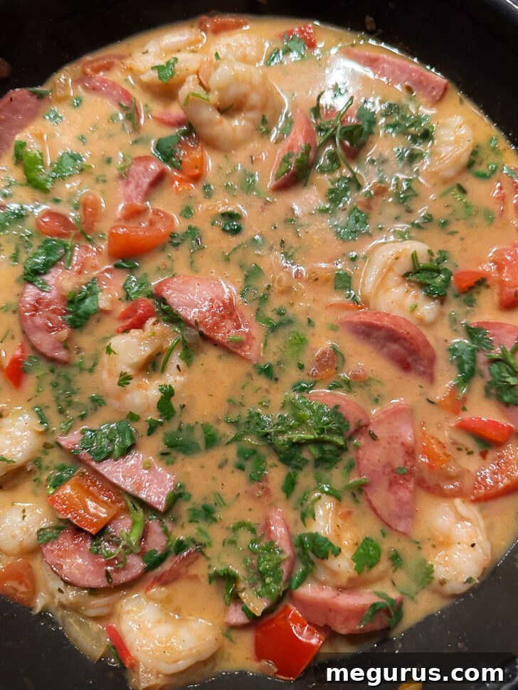 The fully cooked Cajun shrimp and sausage dish in a skillet, vibrant and ready to serve.