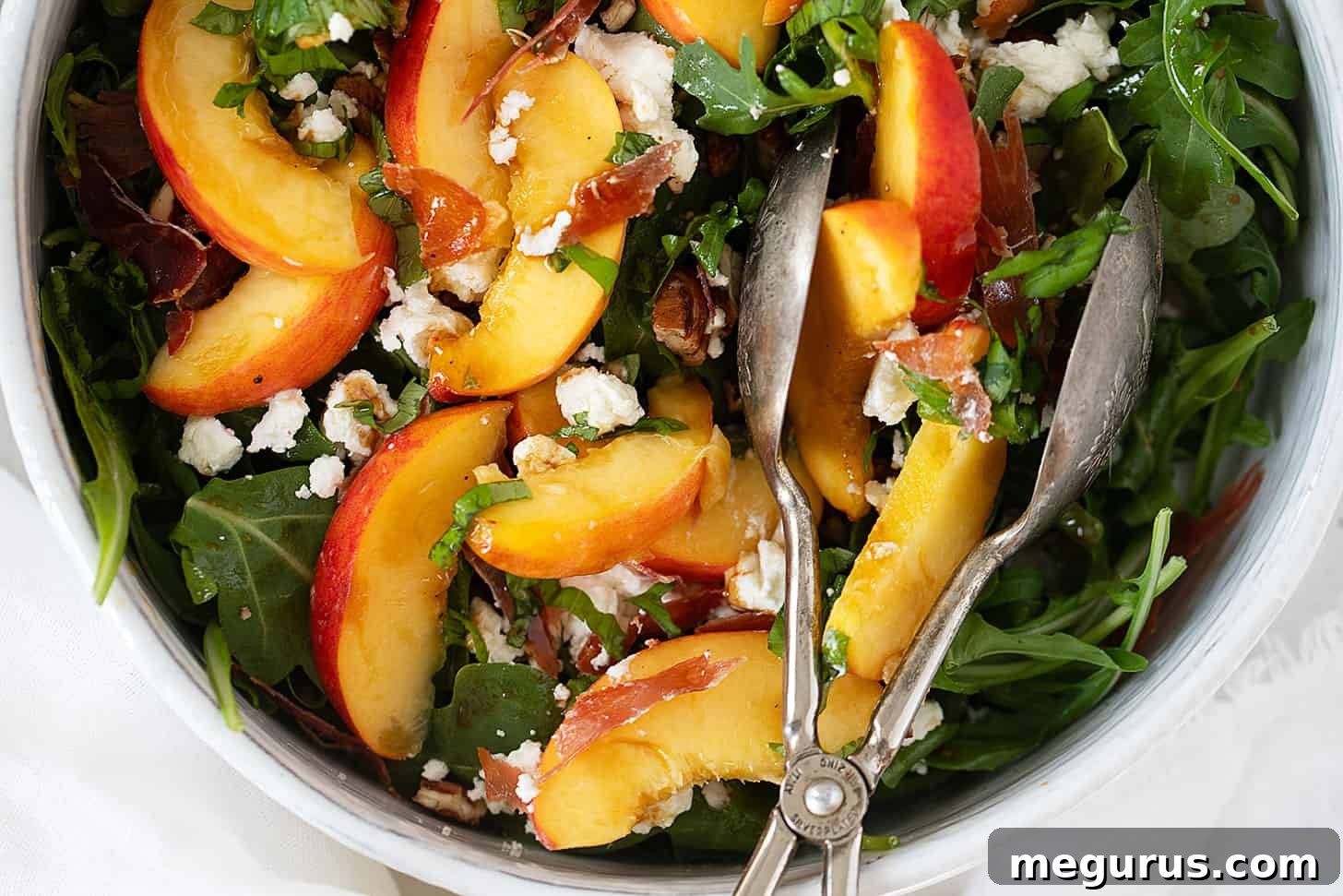 Crispy prosciutto, goat cheese and peach salad in serving bowl.