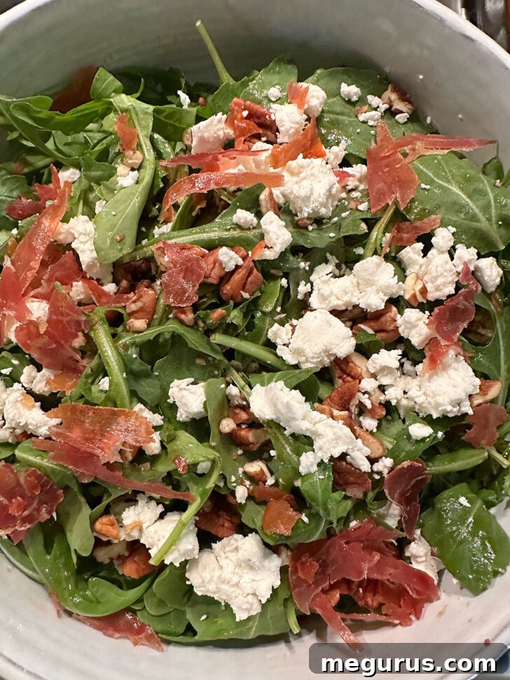 Crispy prosciutto and cheese added to the greens in the bowl.