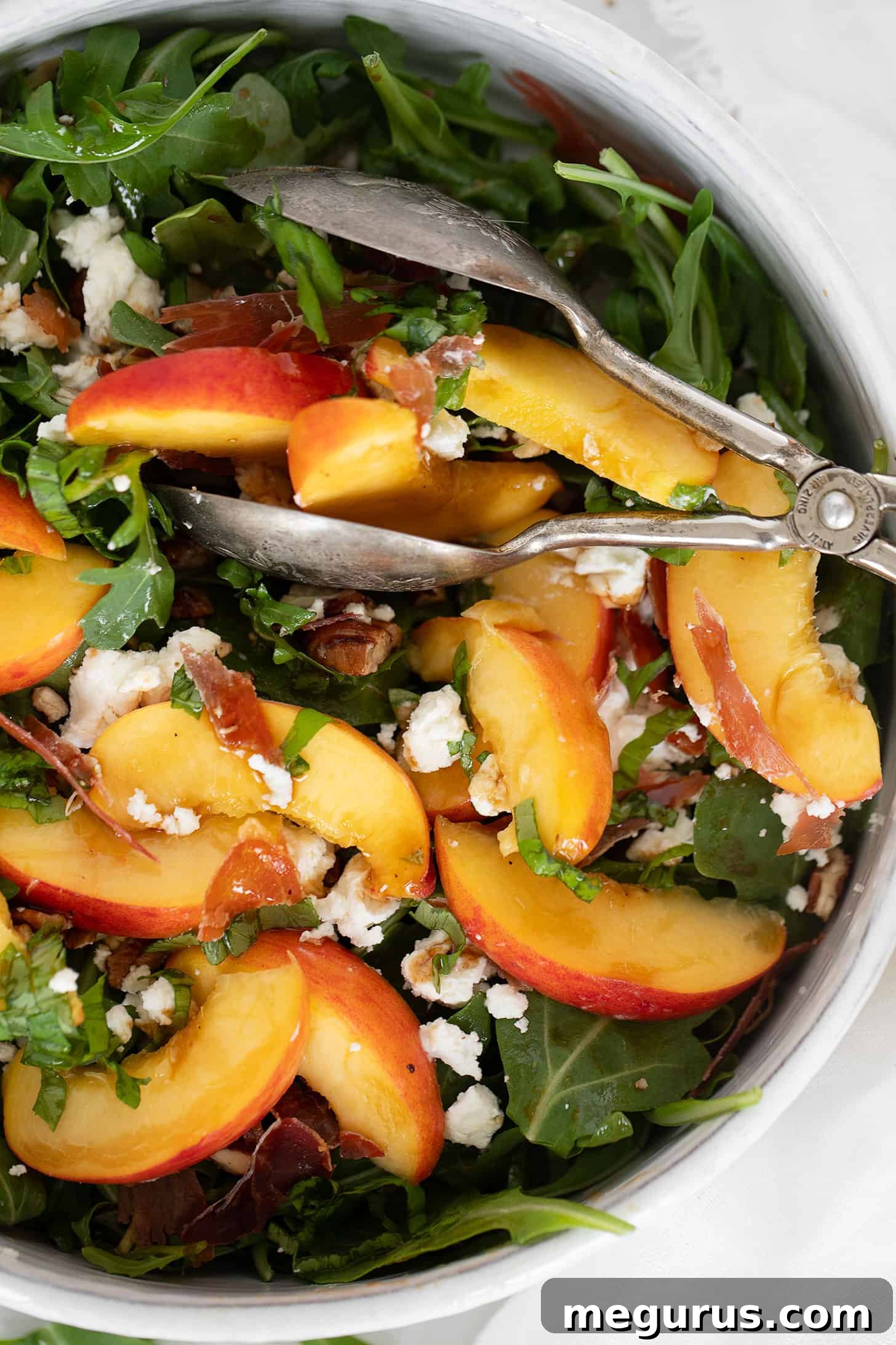 Crispy prosciutto, goat cheese and peach salad in serving bowl.