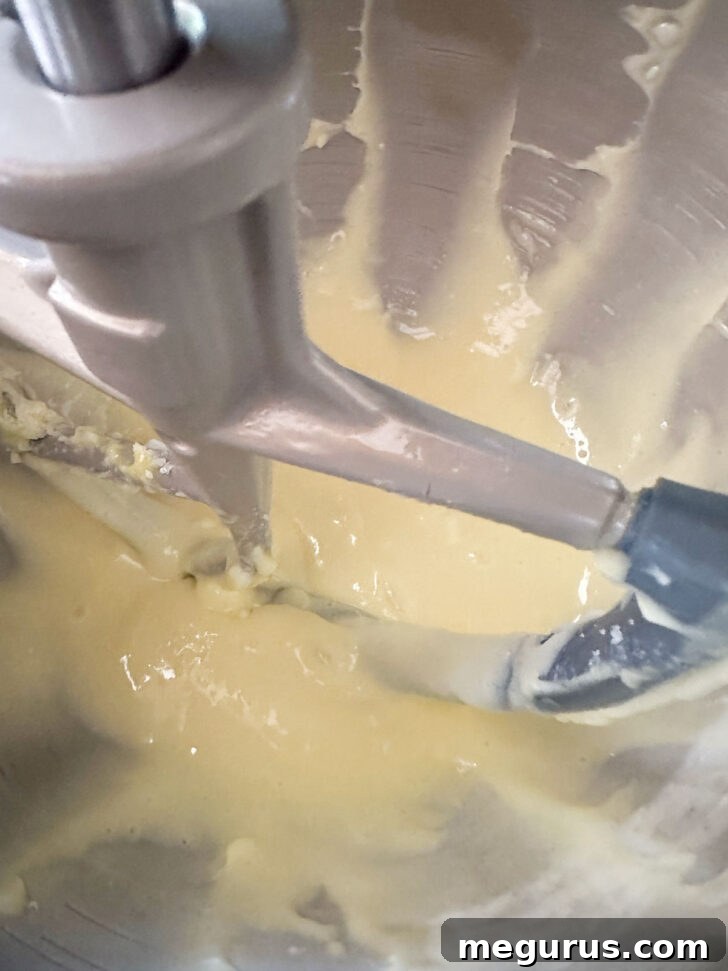 The smooth, well-mixed cake batter in the bowl after the egg has been fully incorporated, displaying a consistent texture.