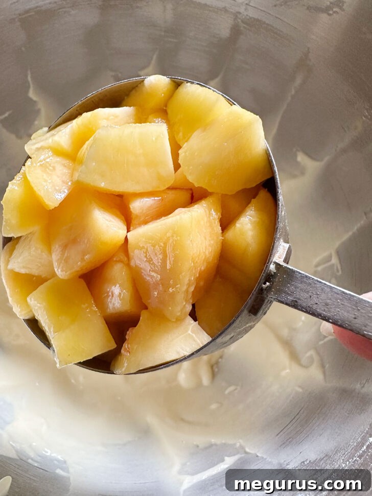 Sweet peach chunks gently folded into the cake batter, ensuring even distribution throughout the mix.