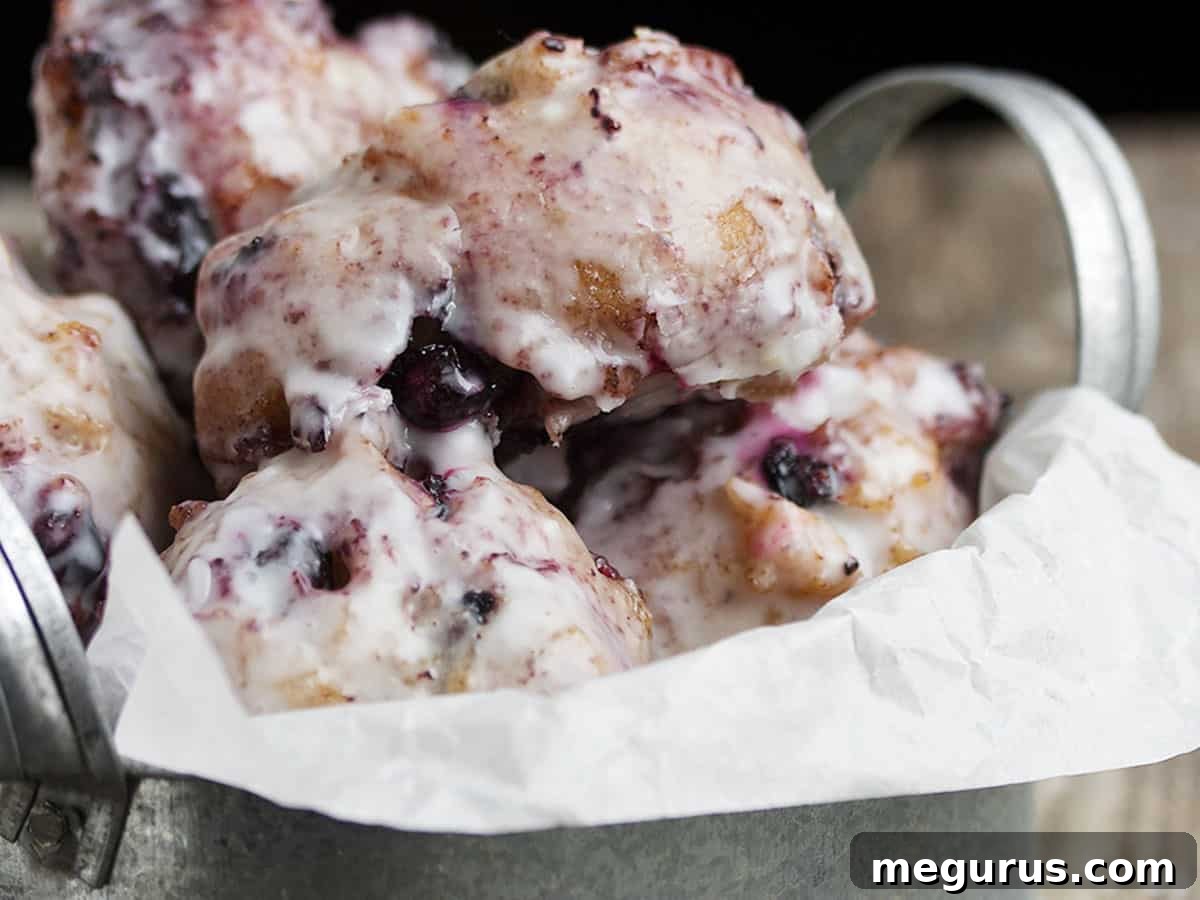 Glazed blueberry fritters in a rustic bucket, ready to be enjoyed