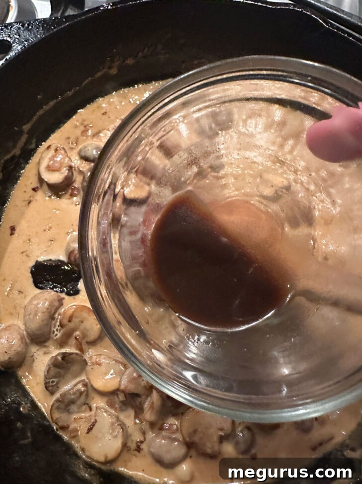Worcestershire sauce being mixed into the rich Diane sauce, adding a layer of complex umami.