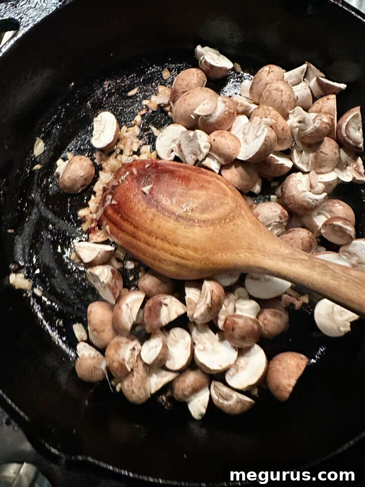 Shallots, garlic, and mushrooms added to the skillet, starting to soften and release their aromas.
