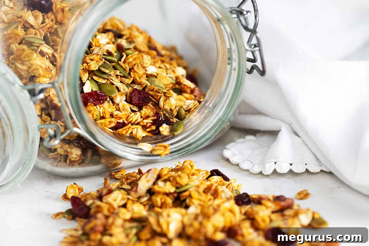 Pumpkin granola spilling out of jar.