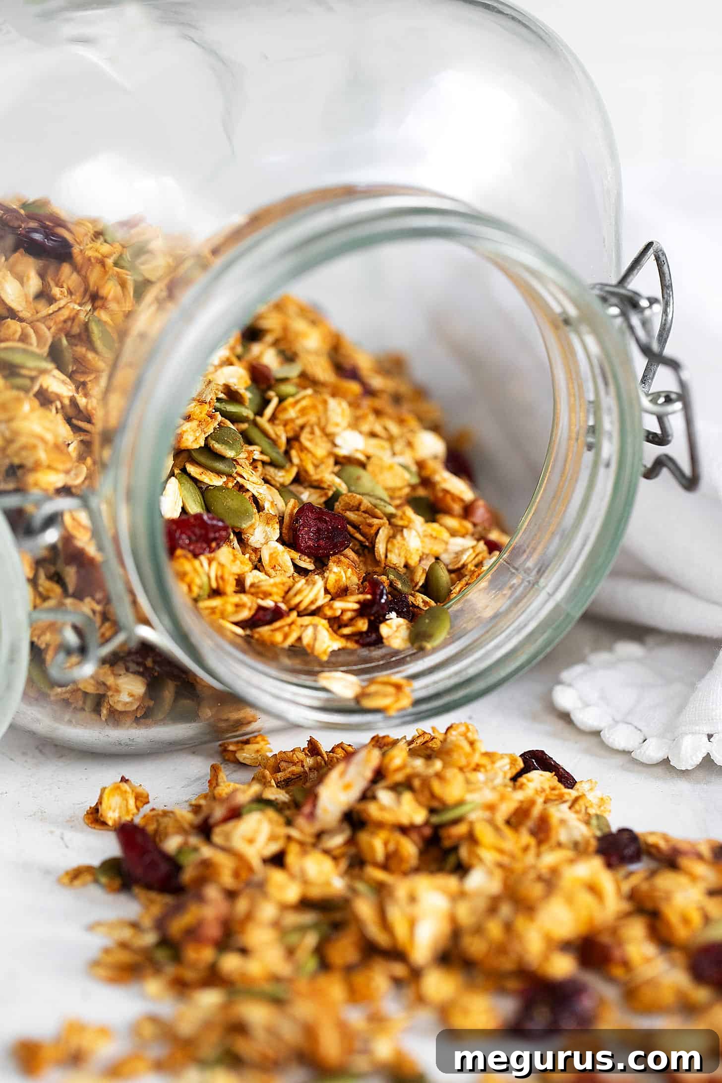 Pumpkin granola spilling out of jar.