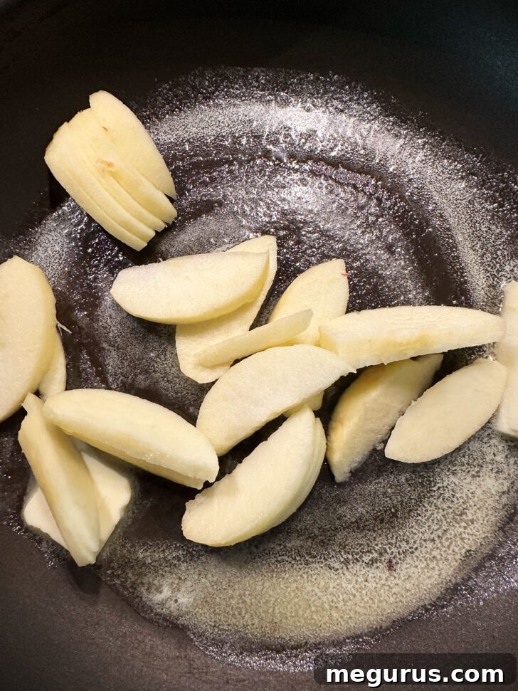Sliced apples added to melted butter in skillet.