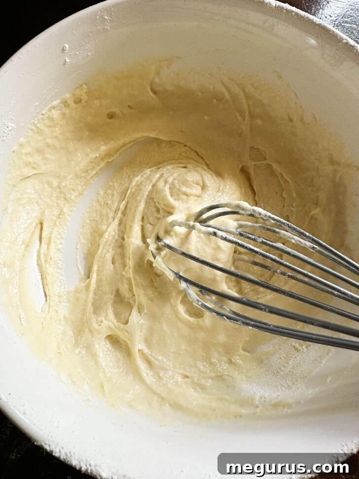 Whisking the egg mixture into the flour mixture.