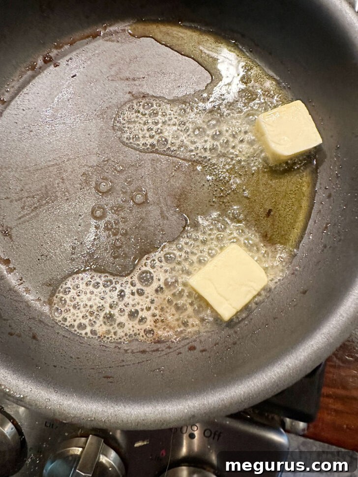 Butter melting in the skillet, forming the base for the rich lemon butter sauce.