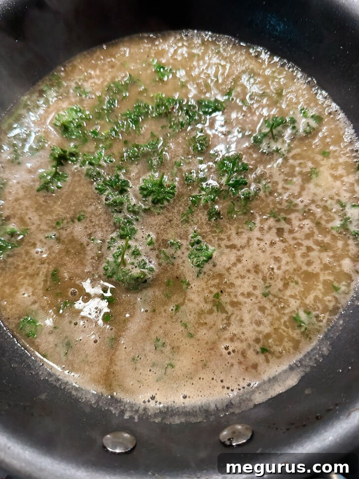Chopped fresh parsley stirred into the finished lemon butter wine sauce in the skillet.
