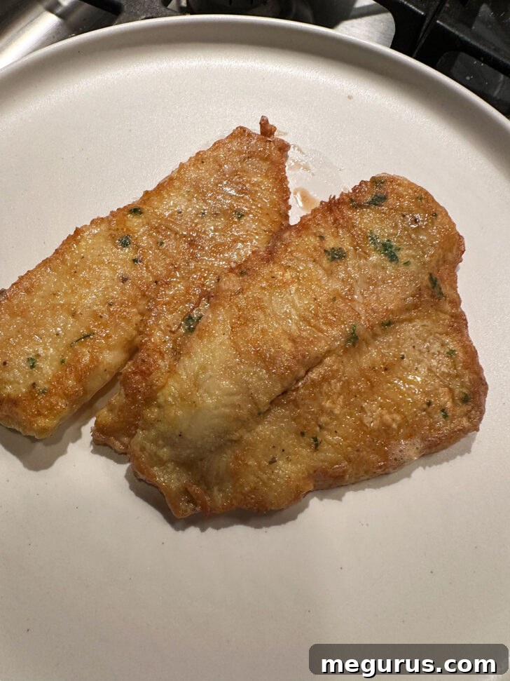 Cooked sole fillets carefully removed from the skillet and placed on a warm plate.