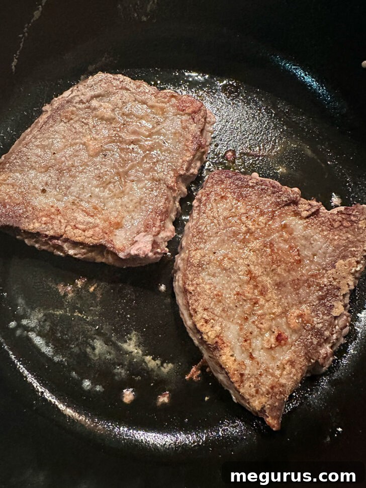 Floured beef steaks after browning in the skillet.