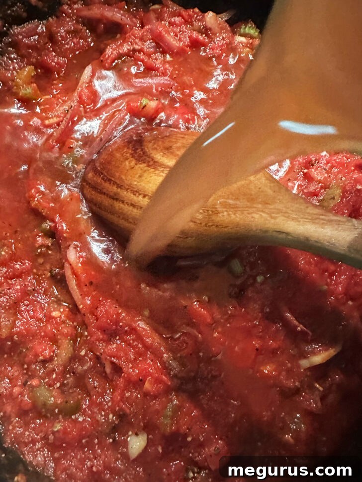 Adding beef broth to the skillet.