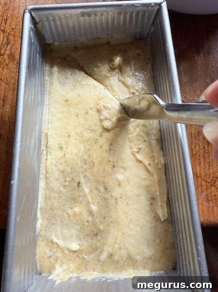 A long skewer or knife gently swirling through the layered batters in the loaf pan to create beautiful marble patterns before baking.