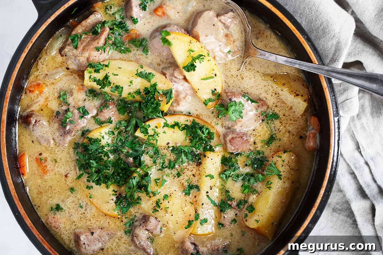 Braised pork with apples in baking dish.
