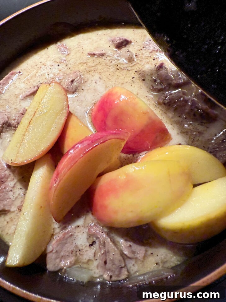 Adding browned apples to the skillet.