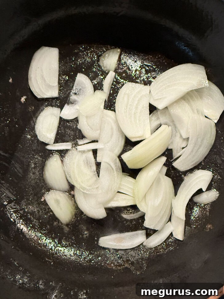 Adding onion to skillet after removing pork.