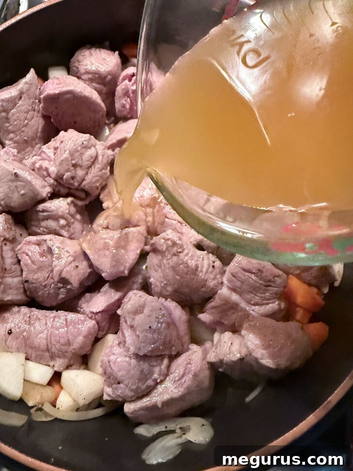 Adding apple cider to the skillet.